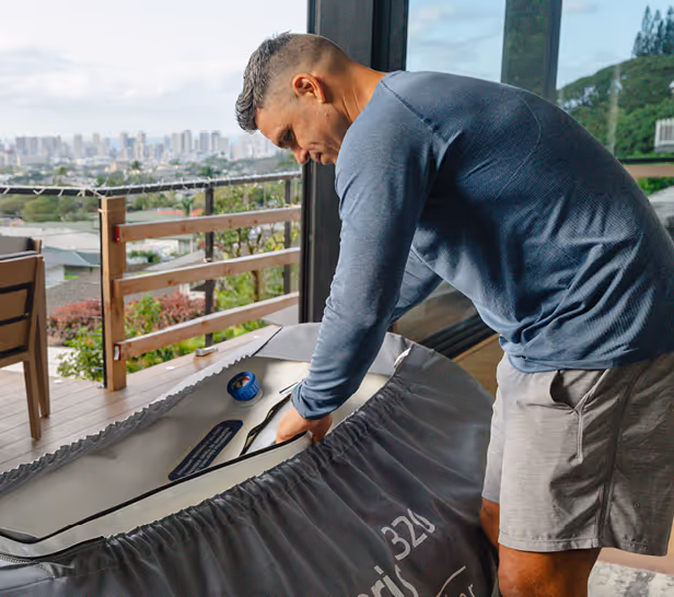 Man preparing a hyperbaric chamber indoors near a glass door